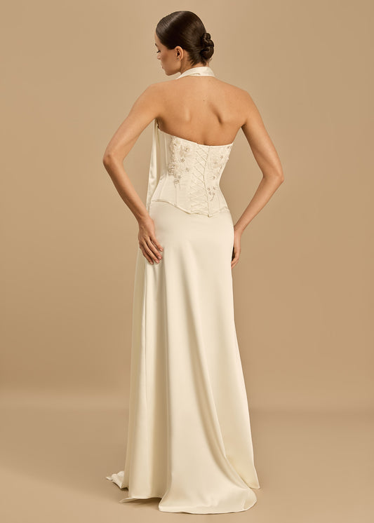 Woman wearing a long, elegant dress with a beige background